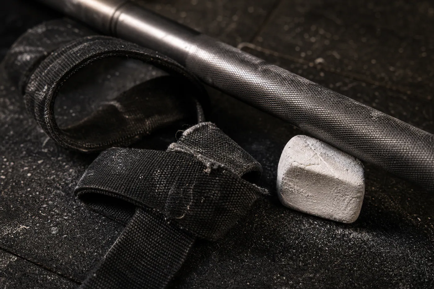 Lifting strap, chalk and barbell detail